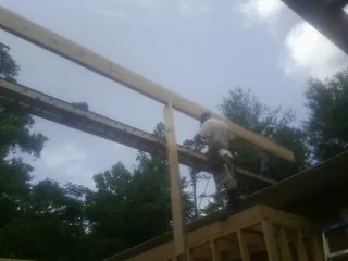Carpenter setting a ridge beam over a new addition frame — Ice Dam Removal by Roofing Brothers in Thompson Falls