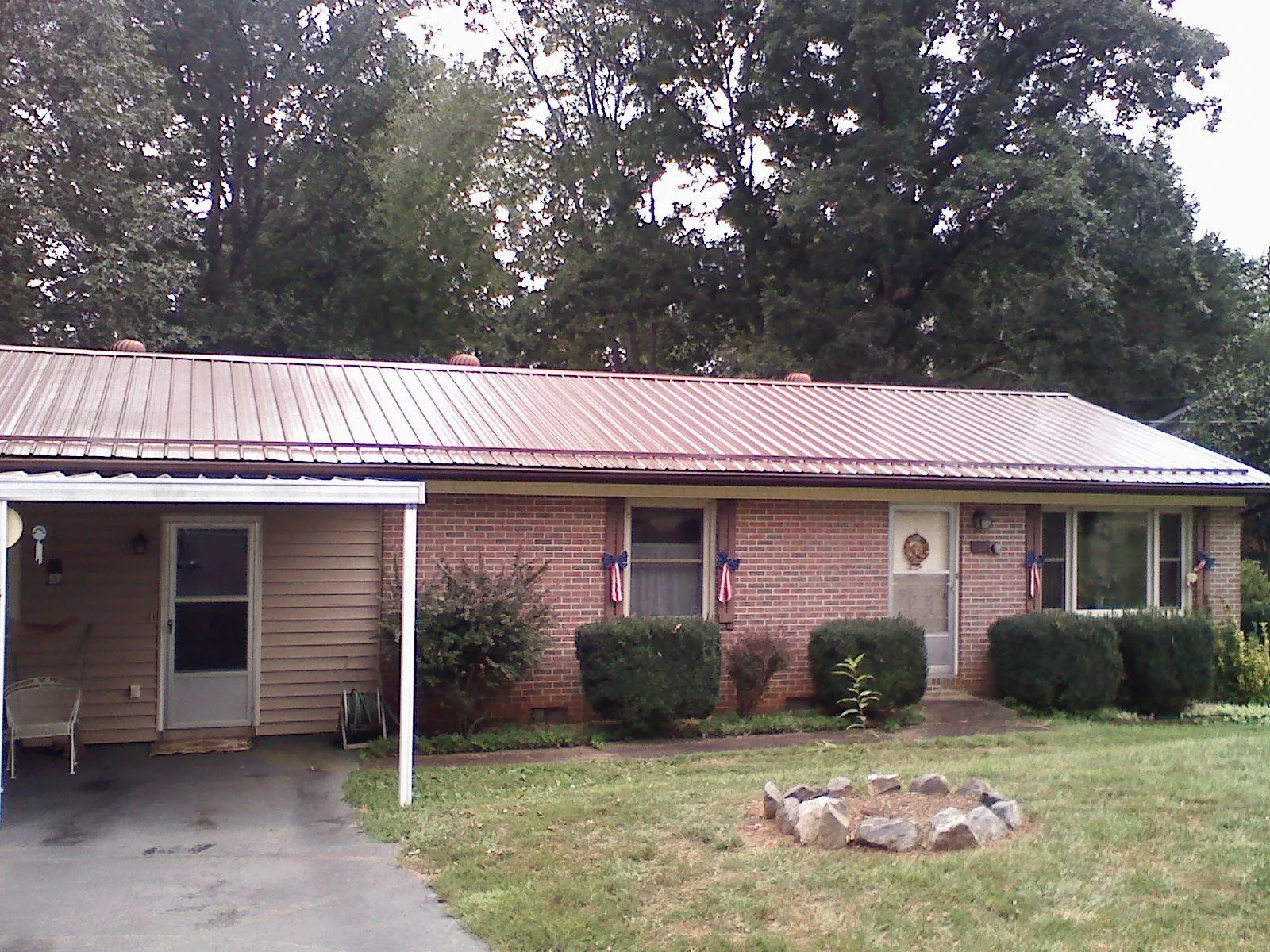 Bronze metal roof and carport on a brick ranch home — Roof Repair work by our crew in Thompson Falls